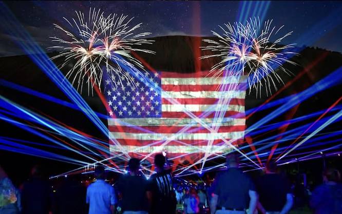 massive fireworks and drone show of the American flag in front of a mountain