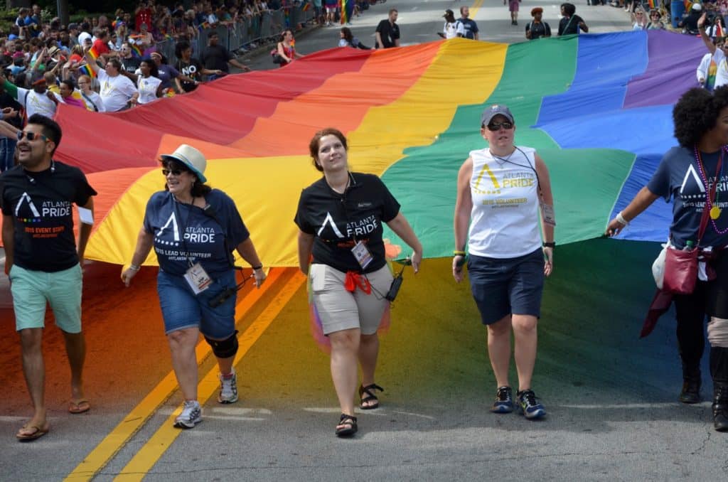 lesbianas desfilando con una bandera del Orgullo