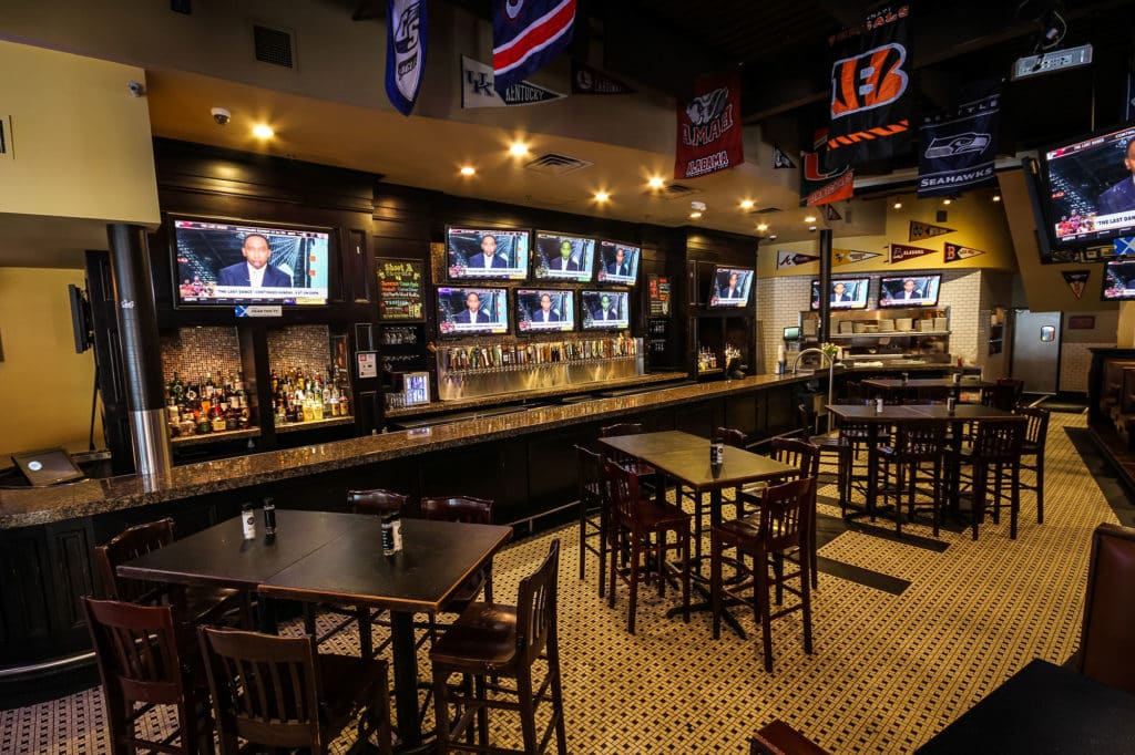 Zona de bar con televisores dentro del Hudson Grille Midtown.