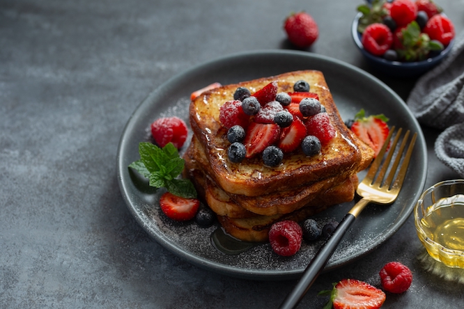 delicious french toasts with honey and fresh berries, dark grey background, copy space