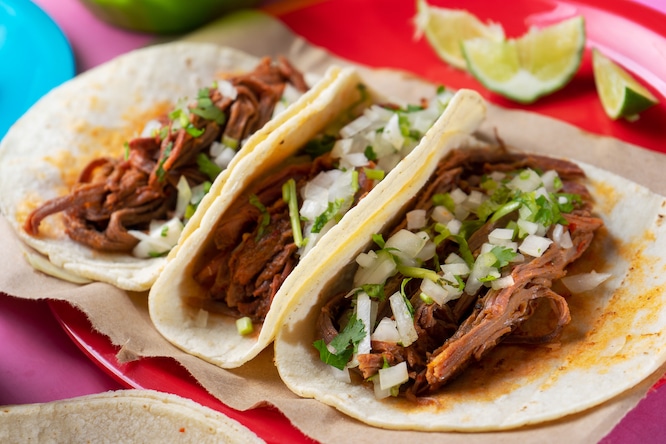 Traditional mexican beef barbacoa tacos on colorful background