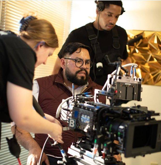 Photo of a camera man filming a scene