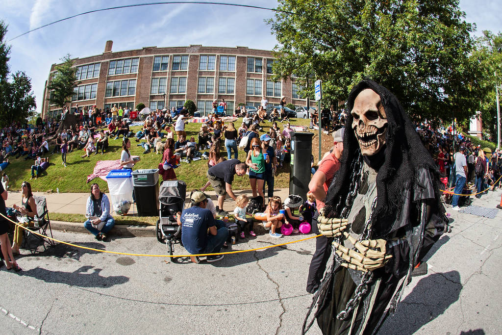 Atlanta, GA, USA - October 21, 2017: A person dressed as the grim reaper walks by a crowd gathering to watch the Little Five Points Halloween Parade on October 21, 2017 in Atlanta, GA.