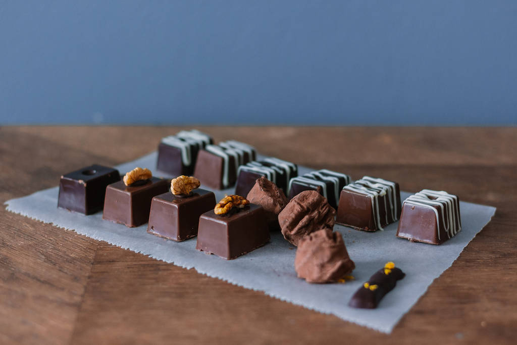 An assortment of fancy Valentine's Day chocolates surrounded on a baking sheet