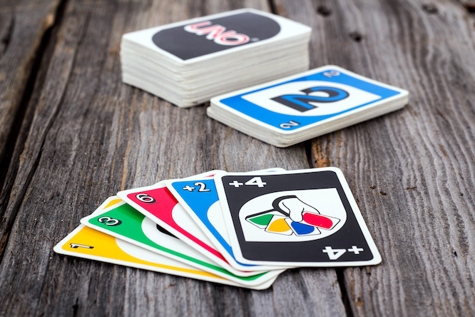 Sorel-Tracy, Canada - January 13, 2016: view of Uno card game on old wood table. The game was developed by Merle Robbins in Ohio, USA in 1971 it is a Mattel product since 1992.