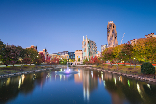 Atlanta, Georgia, USA city skyline from Atlantic Station at dusk with autumn foliage.