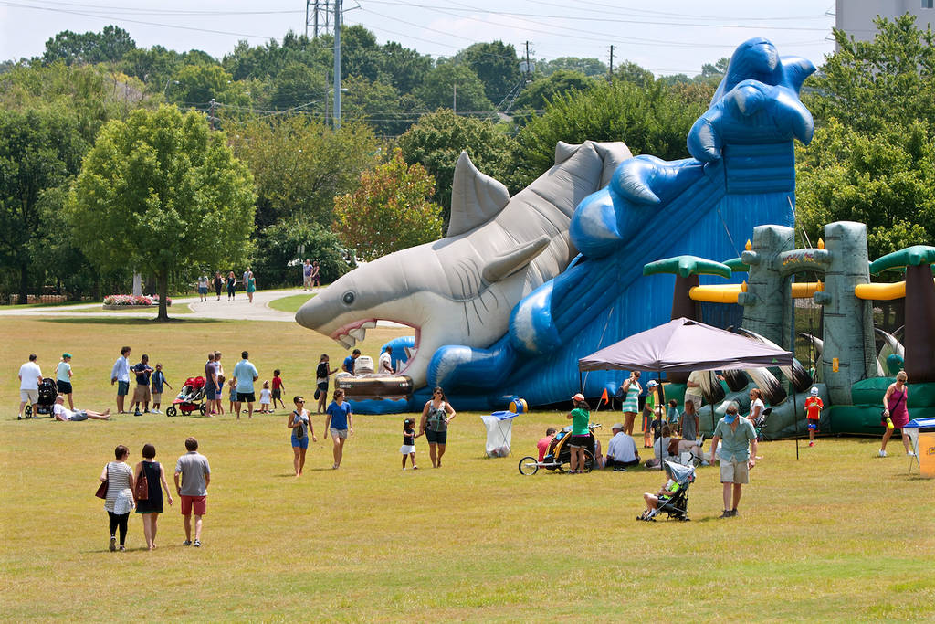 ATLANTA, GA - 16 DE AGOSTO: Las familias caminan hacia y desde un parque infantil inflable gigante en un campo en el Festival de las Artes Piedmont Park, el 16 de agosto de 2014 en Atlanta, GA.