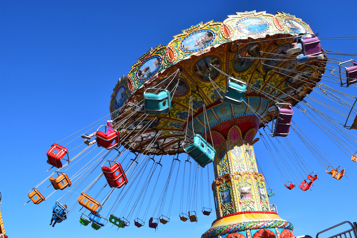 Spinning carousel ride with swings at amusement park.