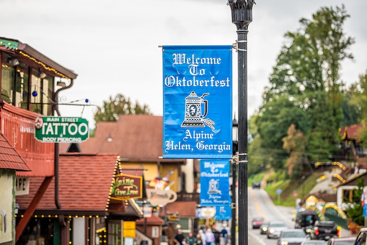 Helen, USA - October 5, 2021: Helen, Georgia Bavarian village stores shops with banner closeup for welcome to Oktoberfest festival on main street by historic architecture buildings