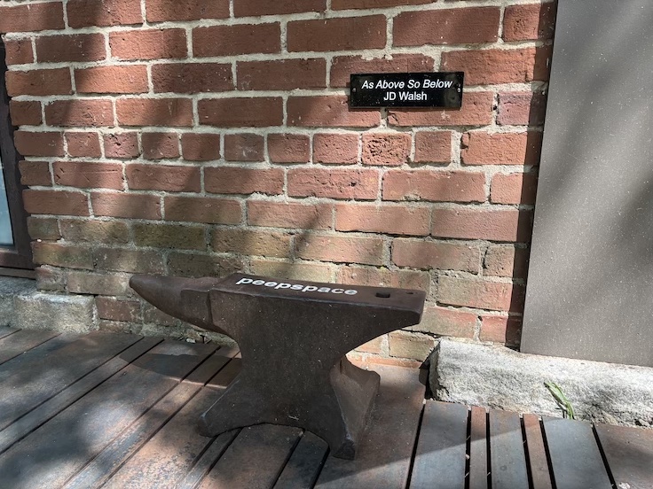 an anvil against a brick wall
