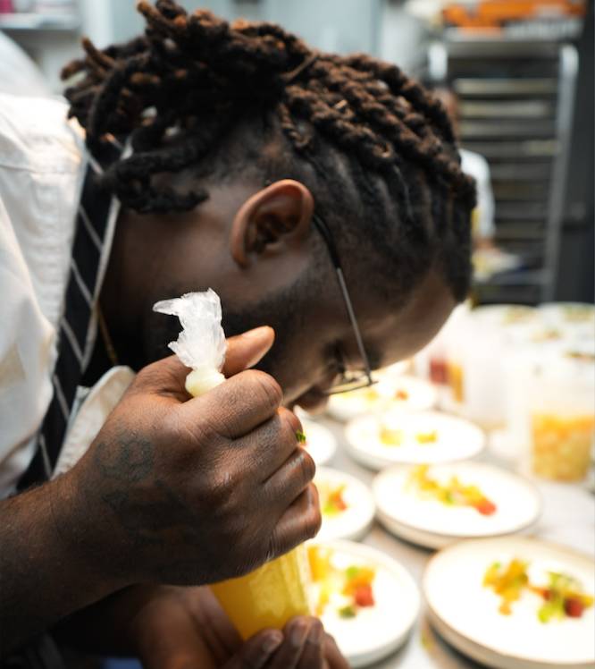 an African-American chef plating food