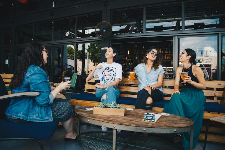 group of female friends laughing at a table