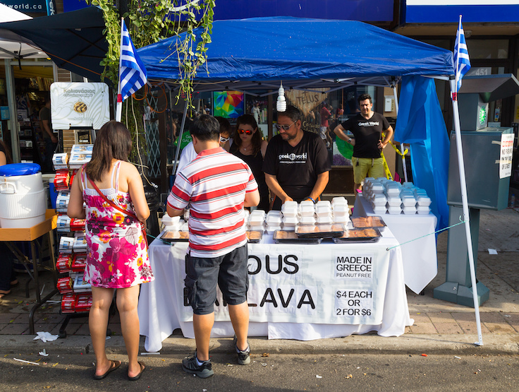TORONTO, CANADA - 10 AUGUST 2014: A food stall during the Taste of Danforth Street Festival showing people serving and people browsing