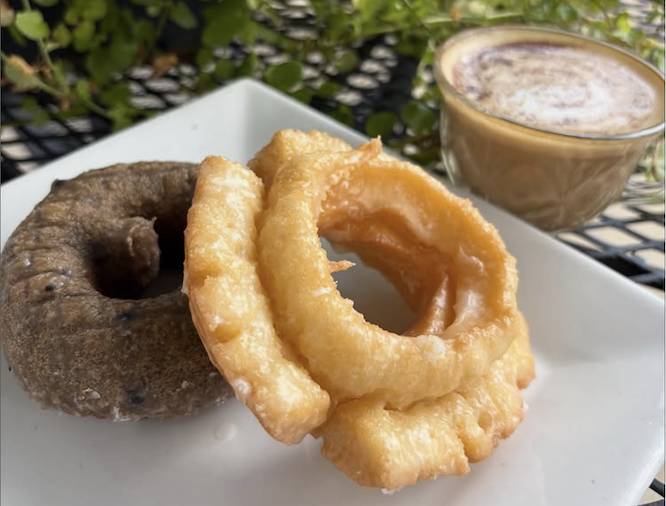 donuts on a white plate with a cup of coffee