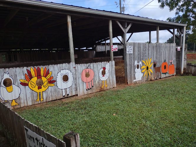 animals painted on a fence for kids to put their faces in for a photo