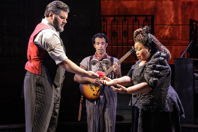 two people making a deal in front of a guitarist