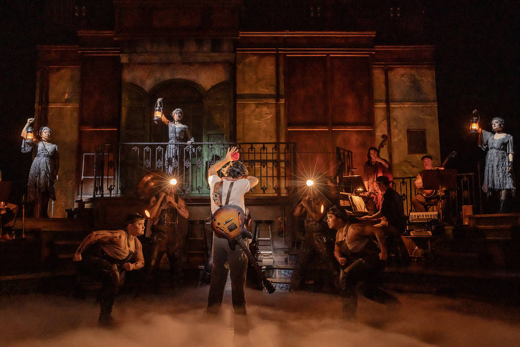 versión escénica de Hadestown con luces brillantes y calidad de producción