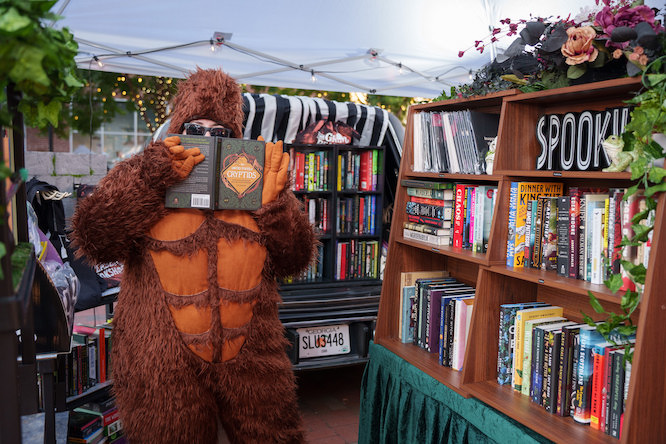 huge bookshop located in a hearse. A person dressed as Big Foot is in front of it