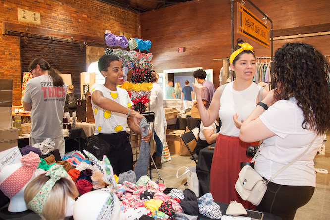 women looking at headbands at a market