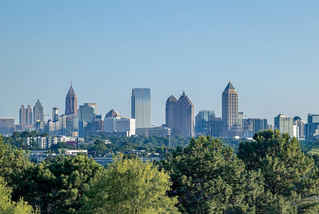 Downtown Atlanta Skyline showing several prominent buildings and hotels under a blue sky.