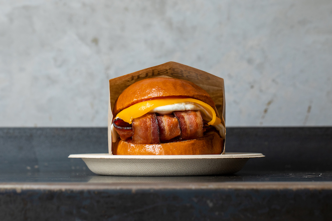fancy bacon egg and cheese sandwich in a little paper bag