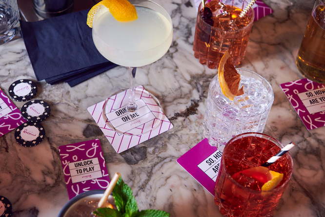 fancy drinks on a coaster that says "drinks on me"