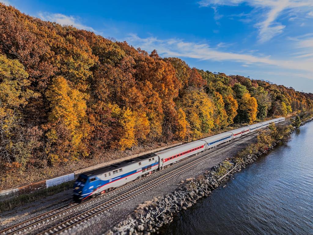 New Hamburg, NY Estados Unidos - 25 de octubre de 2024: Vista aérea del paso del tren Amtrak, tomada desde encima del río Hudson en un día soleado de otoño.