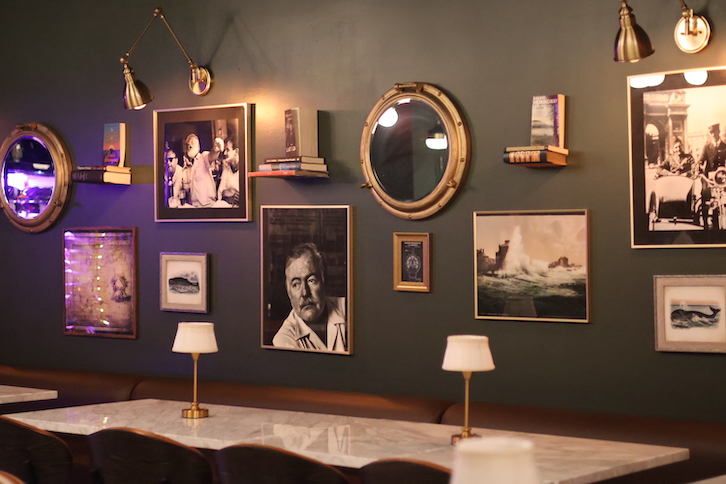 tables with photos of Hemingway above them