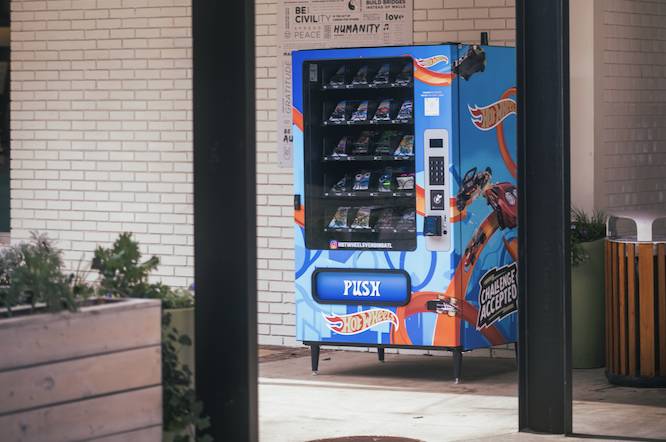 a hot wheels cars vending machine in a coutyard