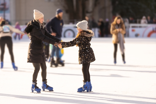 two ice skaters holding hands