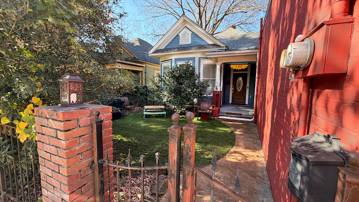 585 blvd exterior of a cute blue home with a brick fence