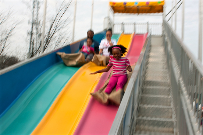 ATLANTA, GA - MARCH 15: Motion blur shows a family sliding down the fun slide at the annual Atlanta Fair, on March 15, 2014 in Atlanta, GA. The fair has been held for three decades.