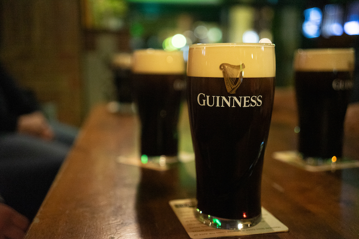 Budapest, Hungary - April 04 2019: illustrative image of Guiness beer on the wooden table top in the Irish bar