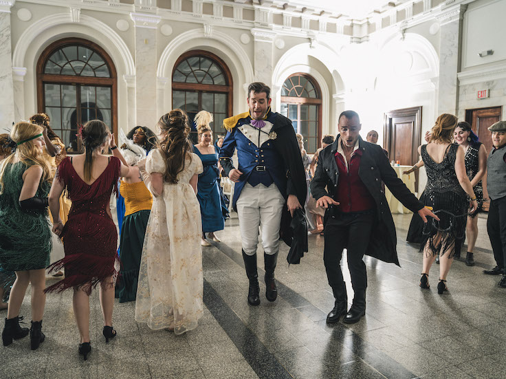 a group of renaissance-dressed people dancing