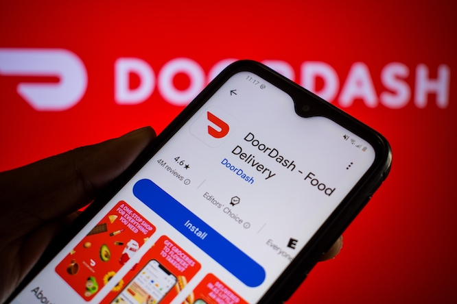 SALT LAKE CITY, UT, USA - SEPT 26, 2024: Man holds smartphone with DoorDash app on Google Play. DoorDash, Inc. is an American company operating online food ordering and food delivery.
