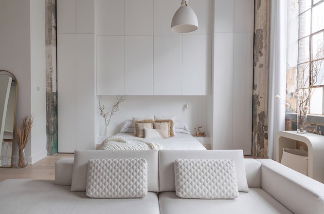 a pretty rental home with white furniture and huge windows