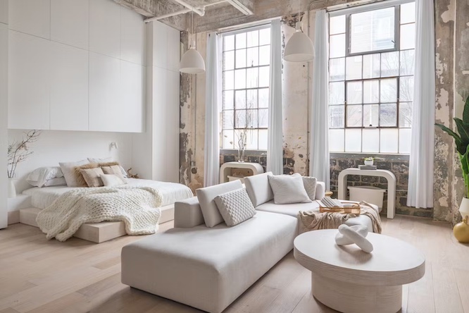 a pretty rental home with white furniture and huge windows