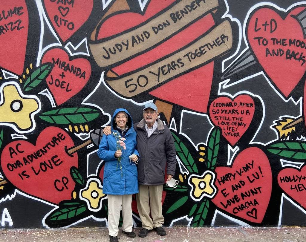 heart mural with a couple in front of it