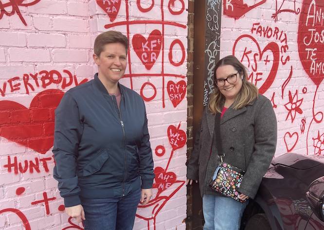 heart mural with a couple in front of it