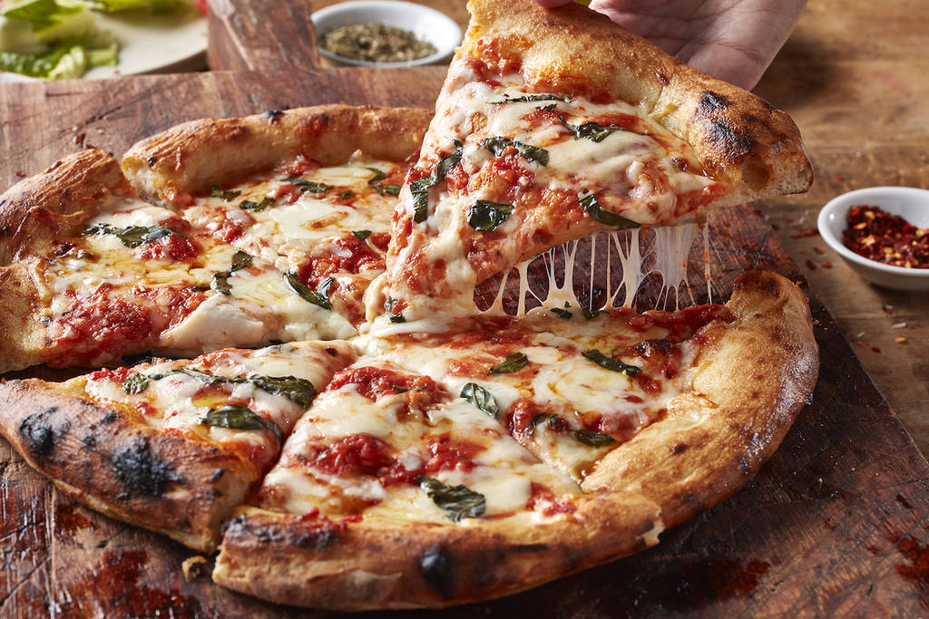 A slice of a delicious classic Margherita pizza on a wooden tray