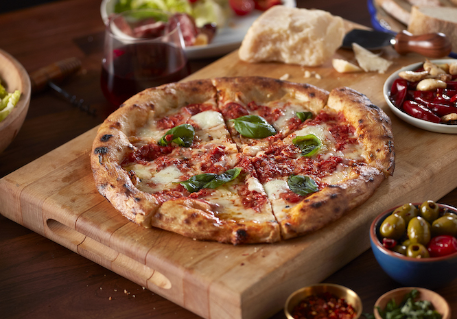 A delicious classic Margherita pizza on a wooden tray