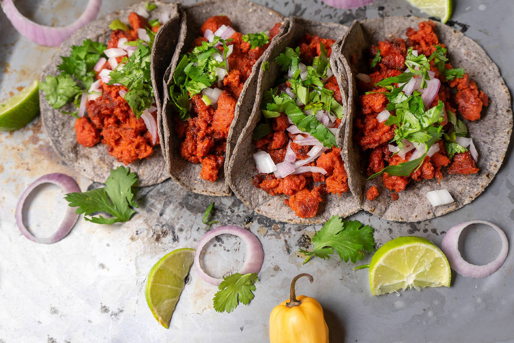 Traditional mexican chorizo tacos with blue corn tortillas on rustic background