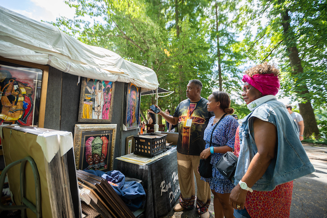 a group of three people look at local art in a park