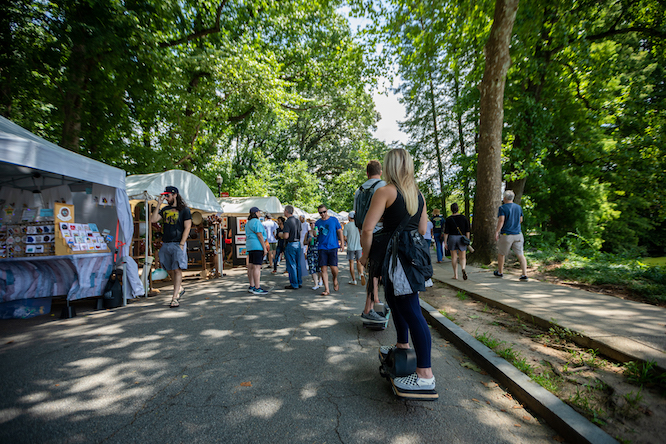 a huge art festival with white tents and a woman standing nearby