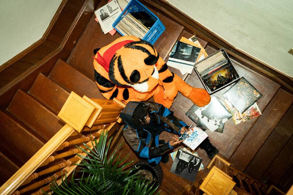 JID and Tony the Tiger sitting on a wooden staircase