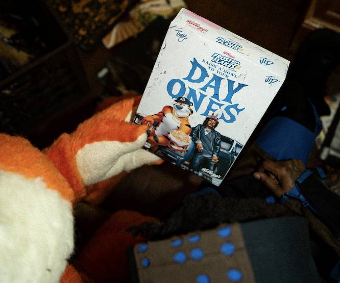 Tony the Tiger's hand holding a cereal box that says 'day ones' on it