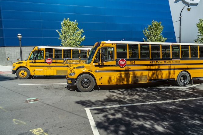 ATLANTA, GEORGIA, USA - OCTOBER 1, 2022: Bright yellow school bus on busy Georgia Aquarium Street