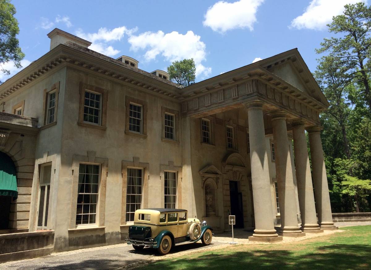 The grand exterior of Swan House in Atlanta with a vintage car outside