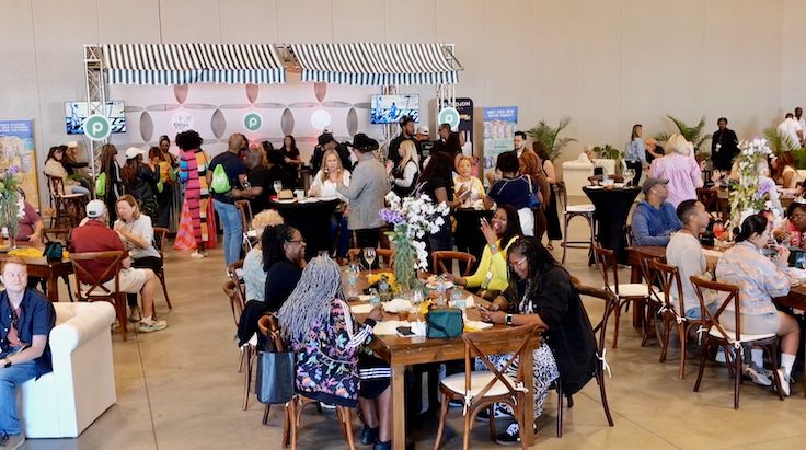 gran festival gastronómico en interior con mesas para comer.