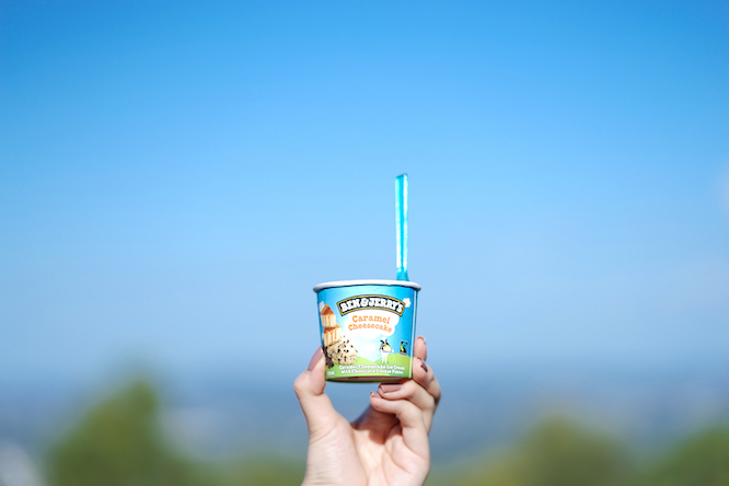 Queensland, Australia - April 15, 2018 : A photo of a hand holding up the cup of Ben and Jerry's ice cream in caramel cheesecake flavor. Editorial use only.